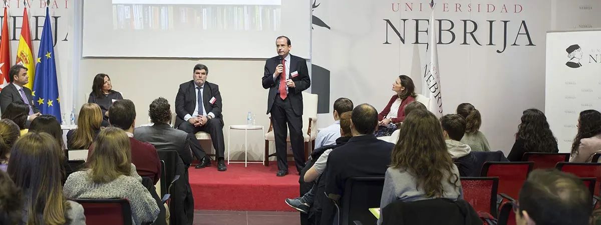Un evento en la Universidad Nebrija con varias personas en un panel de discusión.