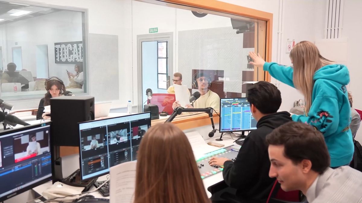 Un grupo de estudiantes está trabajando en un estudio de grabación con monitores y equipos de sonido.