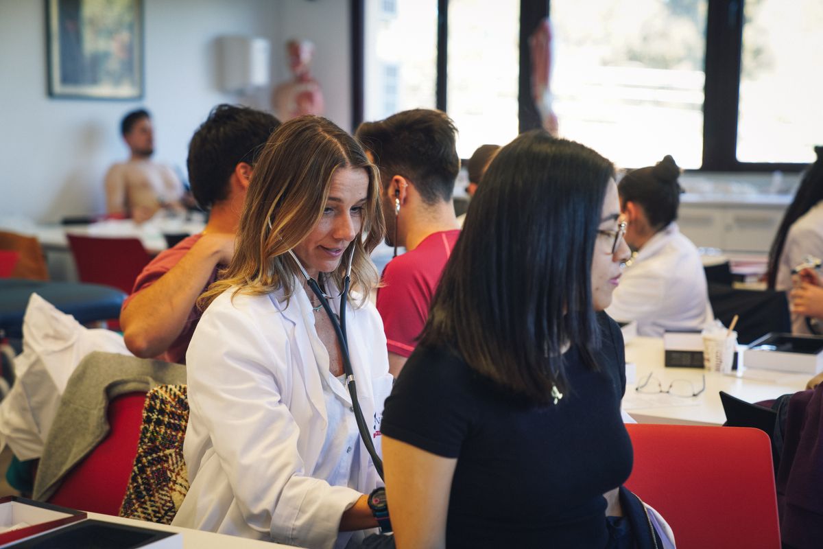 Un grupo de estudiantes se encuentra en un aula con un ambiente académico y colaborativo.