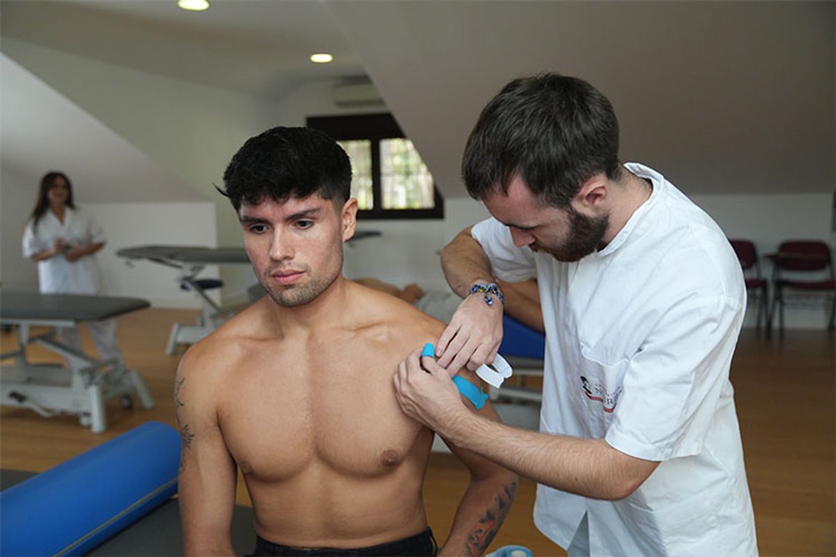 Un fisioterapeuta está tratando a un paciente en una sala de terapia física.