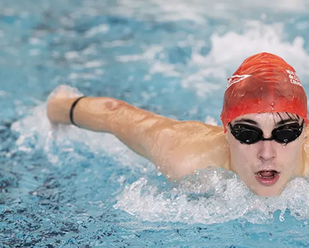 Un nadador compite en una piscina con esfuerzo y concentración.