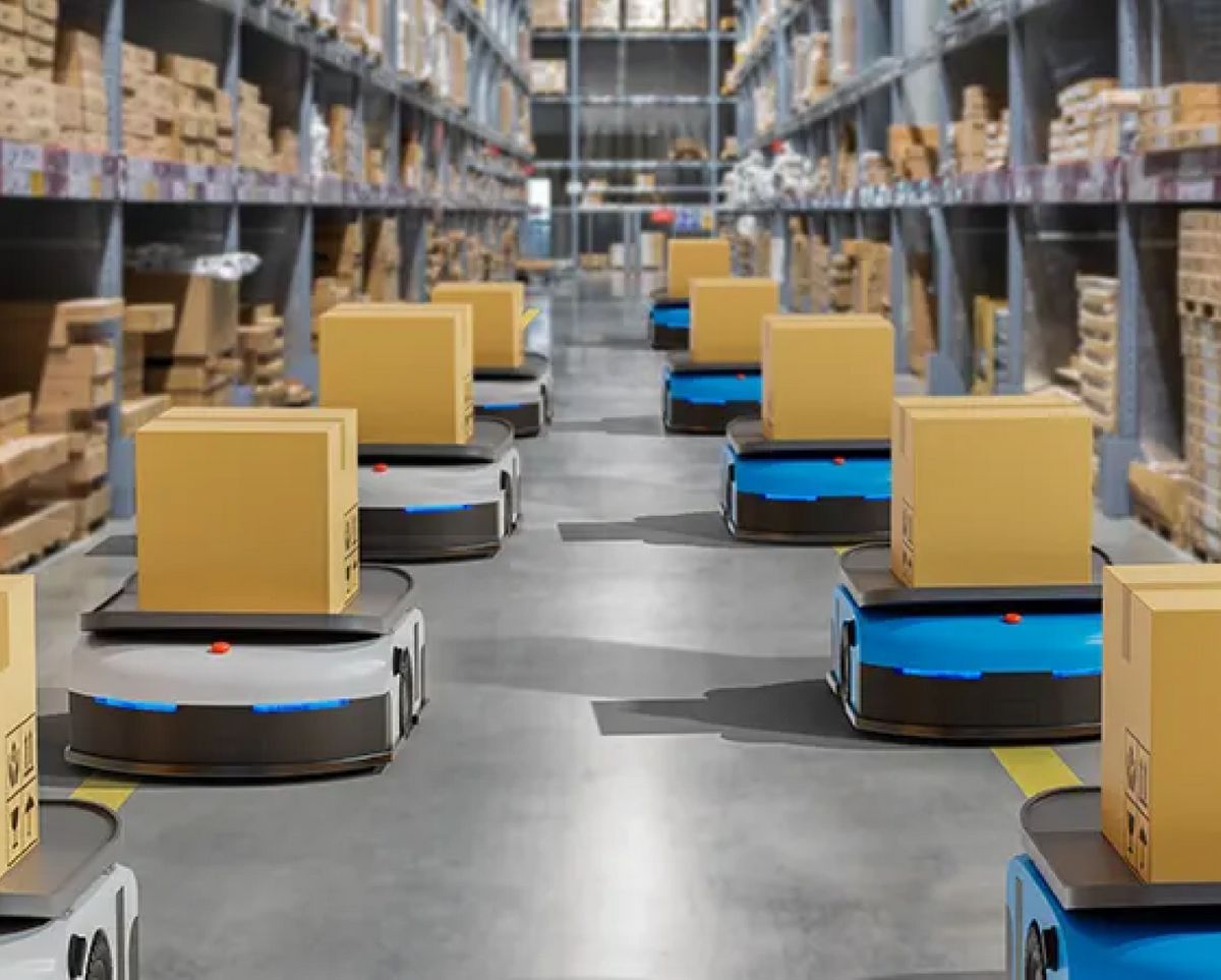 Un almacén con robots autónomos transportando cajas de cartón.