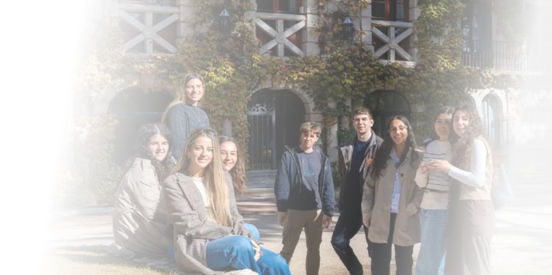 Un grupo de jóvenes sonrientes se encuentra posando juntos en un ambiente al aire libre.