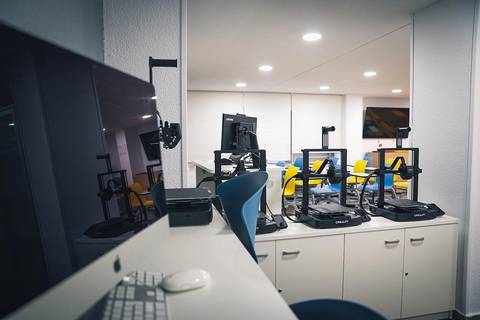 Una oficina moderna con varias estaciones de trabajo y muebles coloridos.