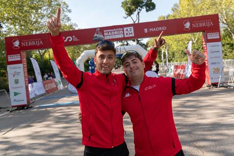 Dos corredores posan alegres frente a la meta del Maratón de Madrid.