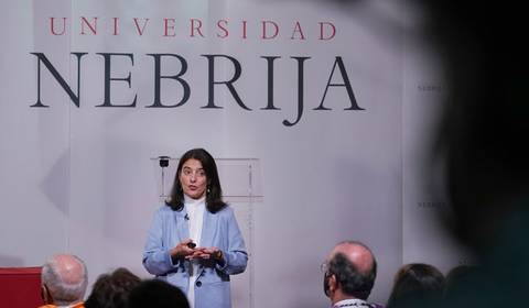 Una mujer está dando una charla en la Universidad Nebrija frente a una audiencia.