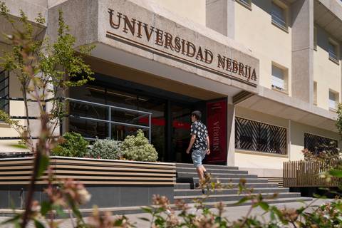 Una persona camina hacia la entrada de la Universidad Nebrija.