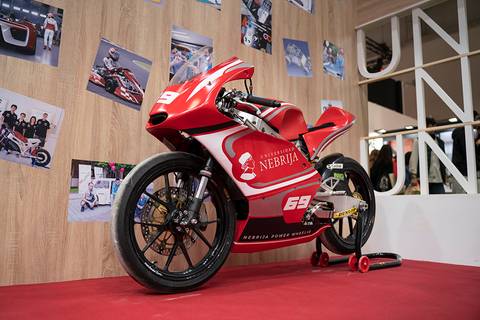 Una motocicleta roja exhibida en un evento, con el logo de la Universidad Nebrija.