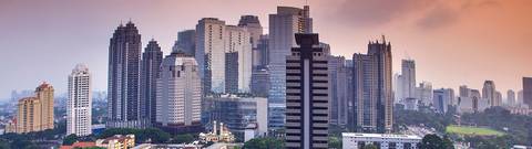 Una vista panorámica de rascacielos en una ciudad moderna durante el atardecer.