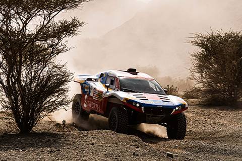 Un vehículo todoterreno compitiendo en un paisaje árido y polvoriento.