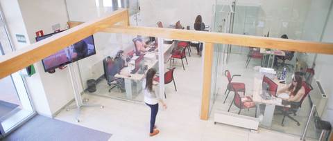 Una sala de estudio moderna con varias personas trabajando en sus computadoras.