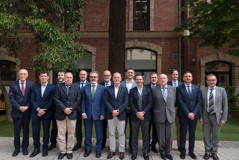 Un grupo de personas posando de pie en un entorno exterior frente a un edificio.