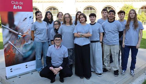 Grupo de jóvenes posando frente a un cartel del Club de Arte.
