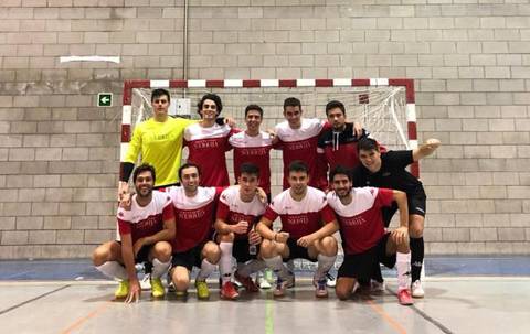 Un grupo de jugadores de fútbol sala posando en equipo frente a la portería.