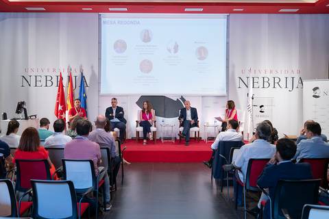 Una mesa redonda llevada a cabo en la Universidad Nebrija con varios ponentes y público asistente.