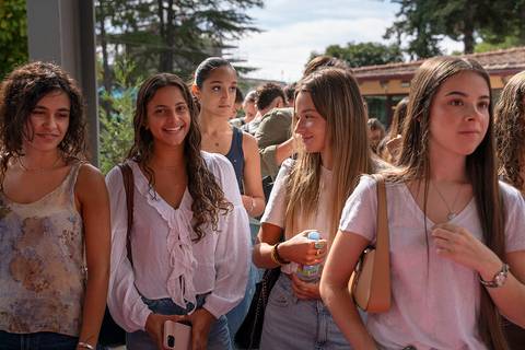 Un grupo de jóvenes sonrientes conversan en un ambiente al aire libre.