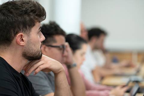 Un grupo de personas concentradas en un aula mientras utilizan computadoras portátiles.