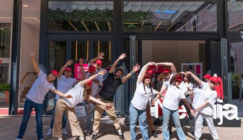 Un grupo de personas sonrientes realiza diferentes poses divertidas frente a un edificio.