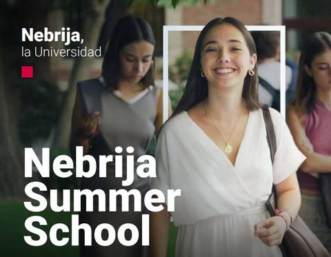 Una mujer sonriente sostiene sus cosas mientras camina por un campus universitario.