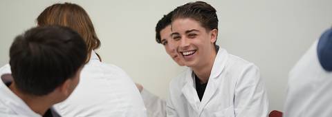 Un grupo de estudiantes sonríe durante una clase en un aula.