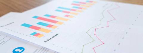La imagen muestra gráficos y datos impresos sobre un informe de negocio.