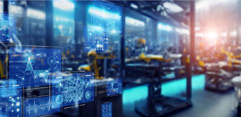 La imagen muestra un entorno industrial con pantallas digitales que presentan gráficos y datos en primer plano.