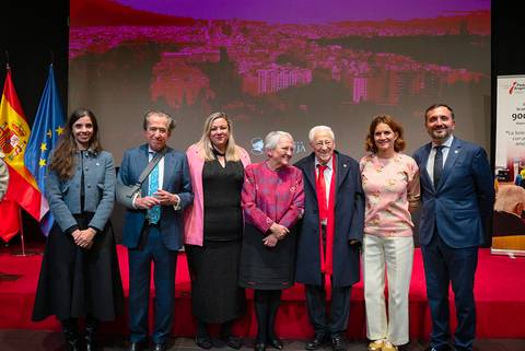 Un grupo de personas posando en un evento con banderas de España y la UE de fondo.