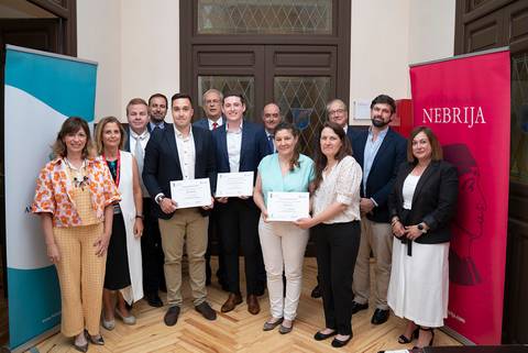Un grupo de personas posando con diplomas en un evento formal.