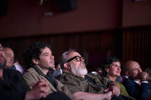 Un grupo de personas observa atentamente una proyección en una sala de cine.