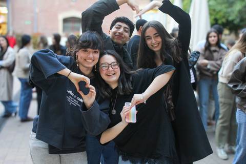 Un grupo de cuatro amigos posando y mostrando signos de afecto en un ambiente festivo.
