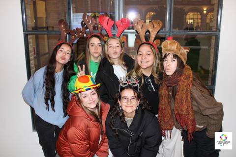 Grupo de amigas posando con adornos festivos y en un ambiente alegre.