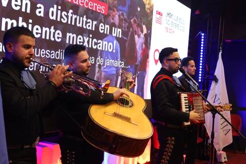 Cuatro músicos interpretan música tradicional en un evento con temática mexicana.