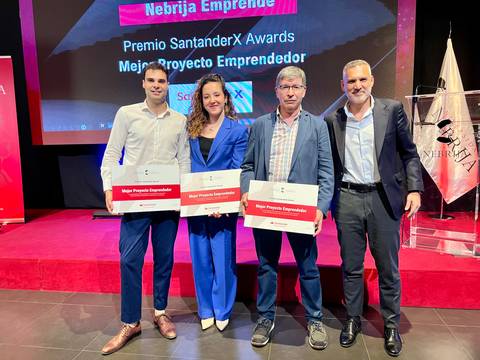 Fotografía de un evento de premiación donde cuatro personas sostienen galardones en reconocimiento a proyectos emprendedores.