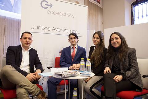 Un grupo de cuatro personas se encuentra en un entorno profesional, posando para la fotografía frente a un cartel de la empresa Codeactivos.