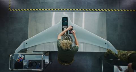 Una persona trabaja en un dron en un entorno de laboratorio.