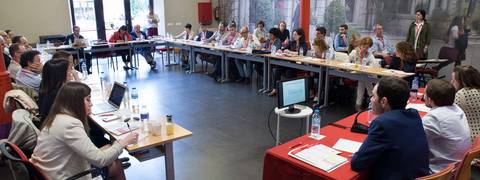 Una reunión en curso con varias personas en una mesa de conferencias.