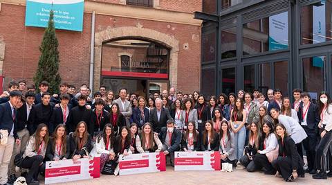 Grupo de estudiantes posando frente a un edificio durante un evento académico.