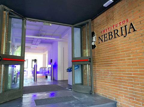 Entrada a los Institutos Nebrija con puertas abiertas y una decoración moderna.