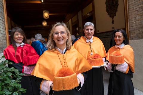 Un grupo de personas posando con atuendos tradicionales y gorros en un evento festivo.