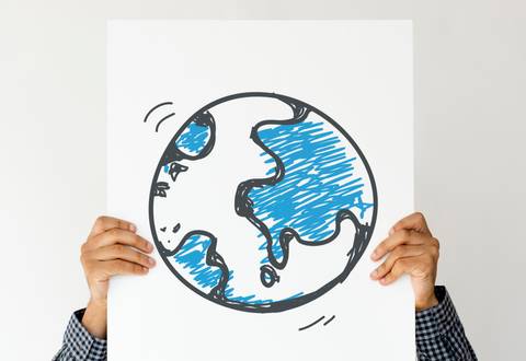 Una persona sostiene un cartel con un dibujo del planeta Tierra.