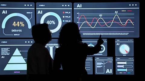Dos personas observan una pantalla con visualizaciones de datos relacionados con inteligencia artificial