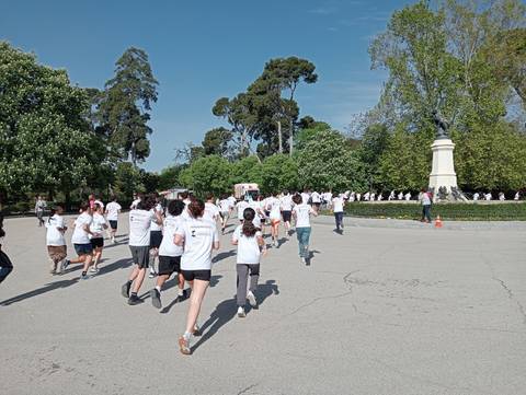 Un grupo de personas corre en un parque luciendo camisetas blancas en un día soleado.