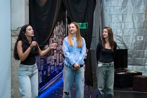 Tres jóvenes conversan en un ambiente artístico y moderno.