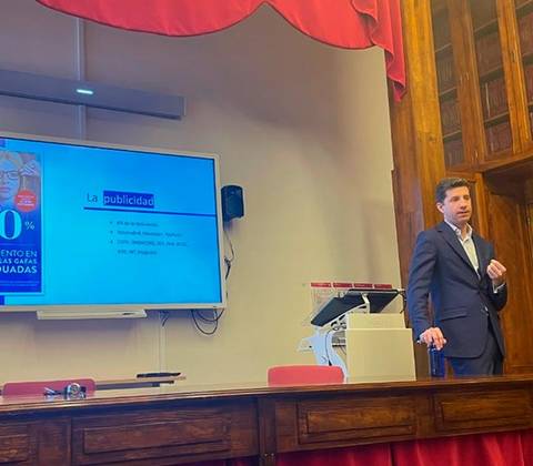 Un hombre de negocios presenta una diapositiva sobre publicidad en una sala de conferencias.