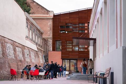 Un grupo de personas se reúne en una terraza en un entorno urbano moderno.