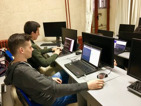 Un grupo de estudiantes trabajando en ordenadores en un aula.