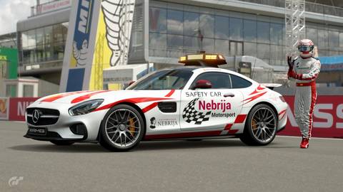 Un coche de seguridad Mercedes-Benz AMG GT con decoraciones de la Universidad Nebrija en un circuito de carreras.