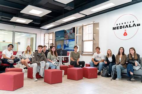 Un grupo de estudiantes se encuentra sentado en un espacio moderno de Medialab, con un ambiente colaborativo.