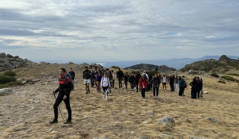 Un grupo de personas camina por un sendero en un paisaje montañoso.