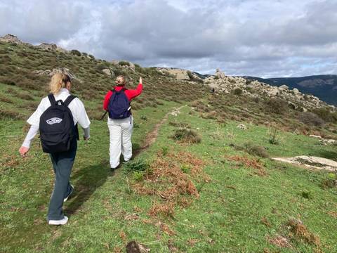 Dos personas caminando por un sendero en un paisaje natural.